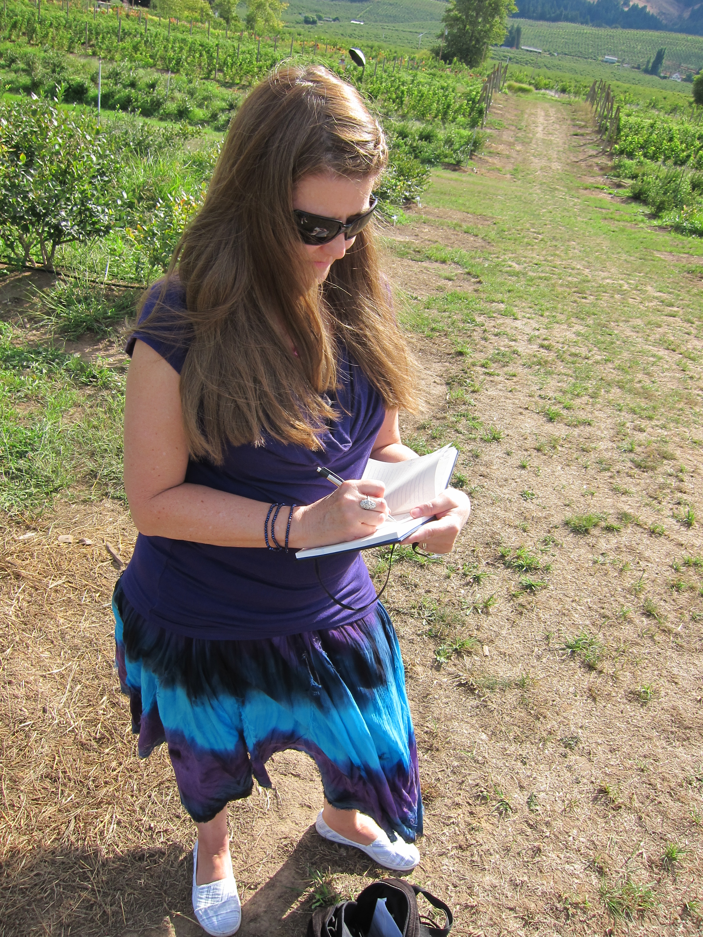 Lianne writing in vineyard